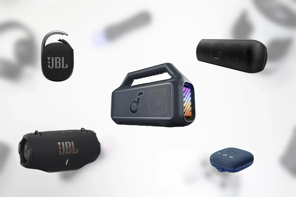 Forskellige bluetooth højtalere på en hvid baggrund med forskellige gadgets spredt omkring.